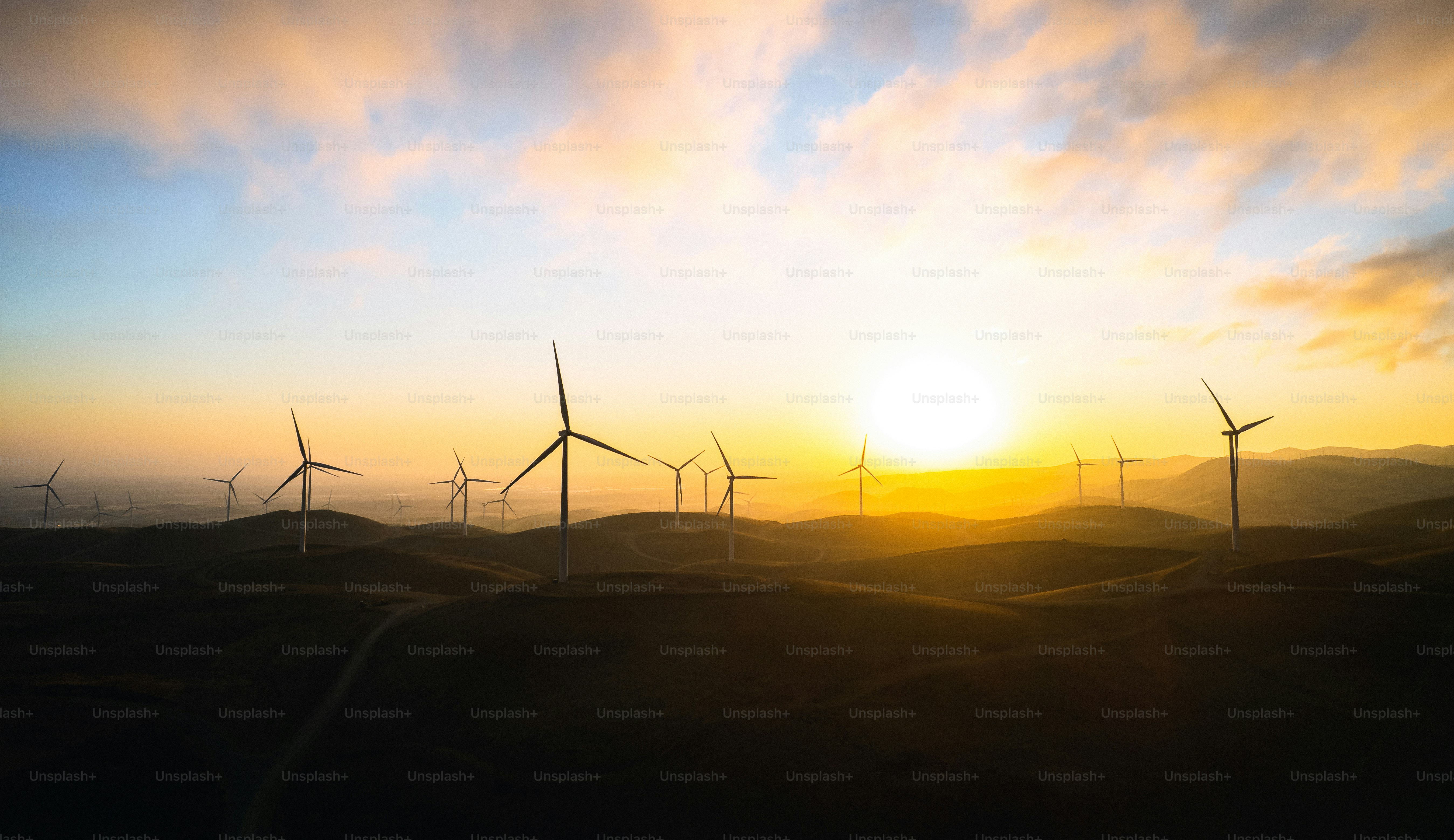 Un groupe de moulins à vent sur une colline au coucher du soleil