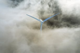a wind turbine in the middle of a cloudy sky