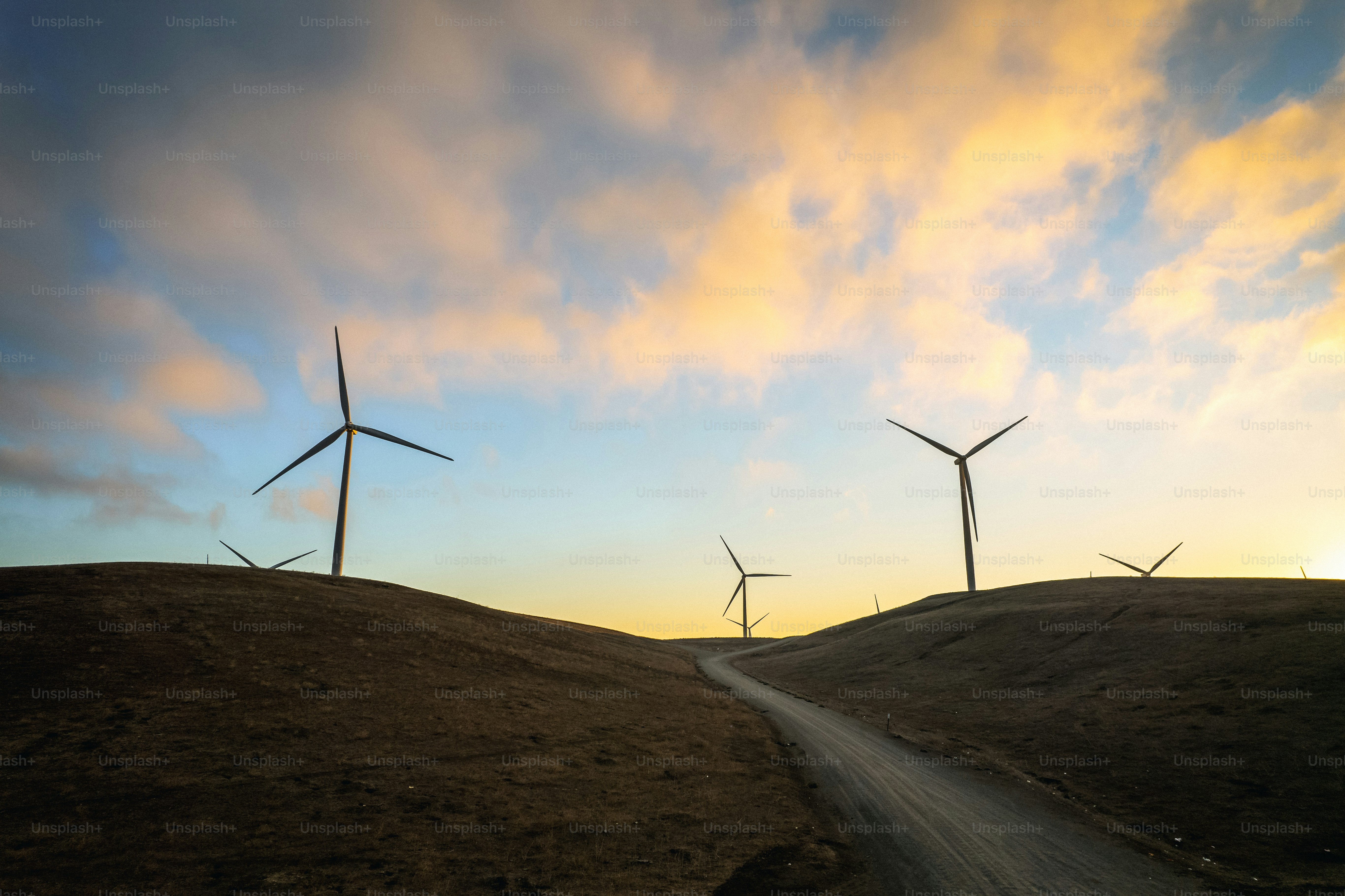 Un groupe de moulins à vent sur une colline au coucher du soleil