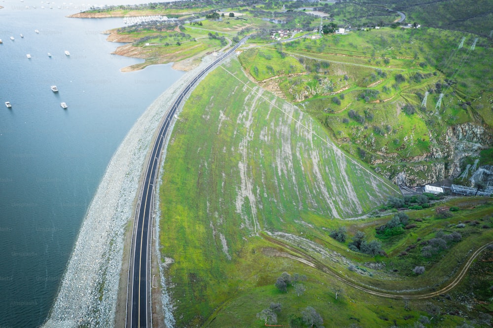 uma vista aérea de uma linha de trem ao lado de um corpo de água
