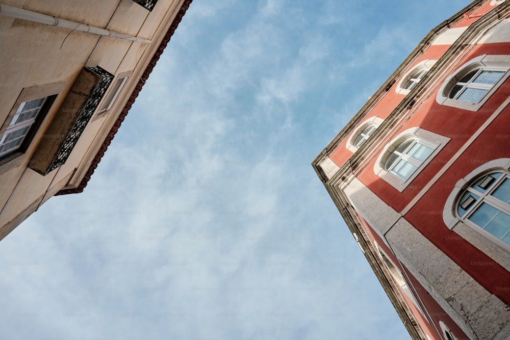 a tall building with two windows and a sky background