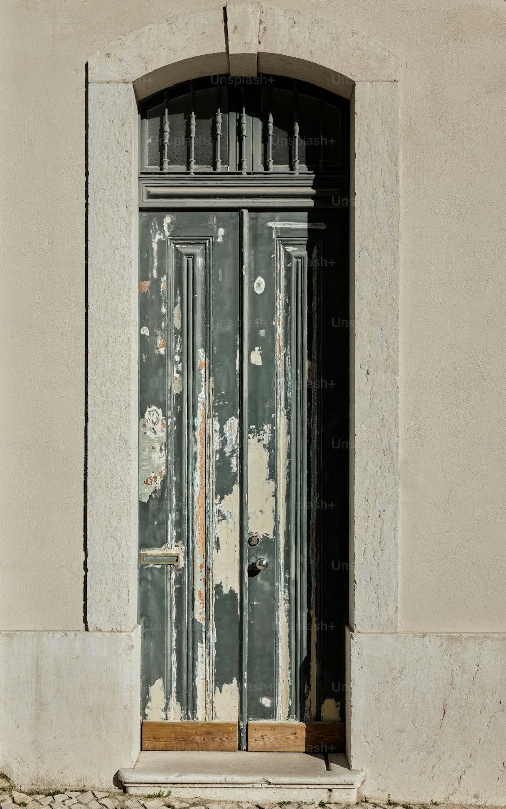 an old door with peeling paint on the side of a building