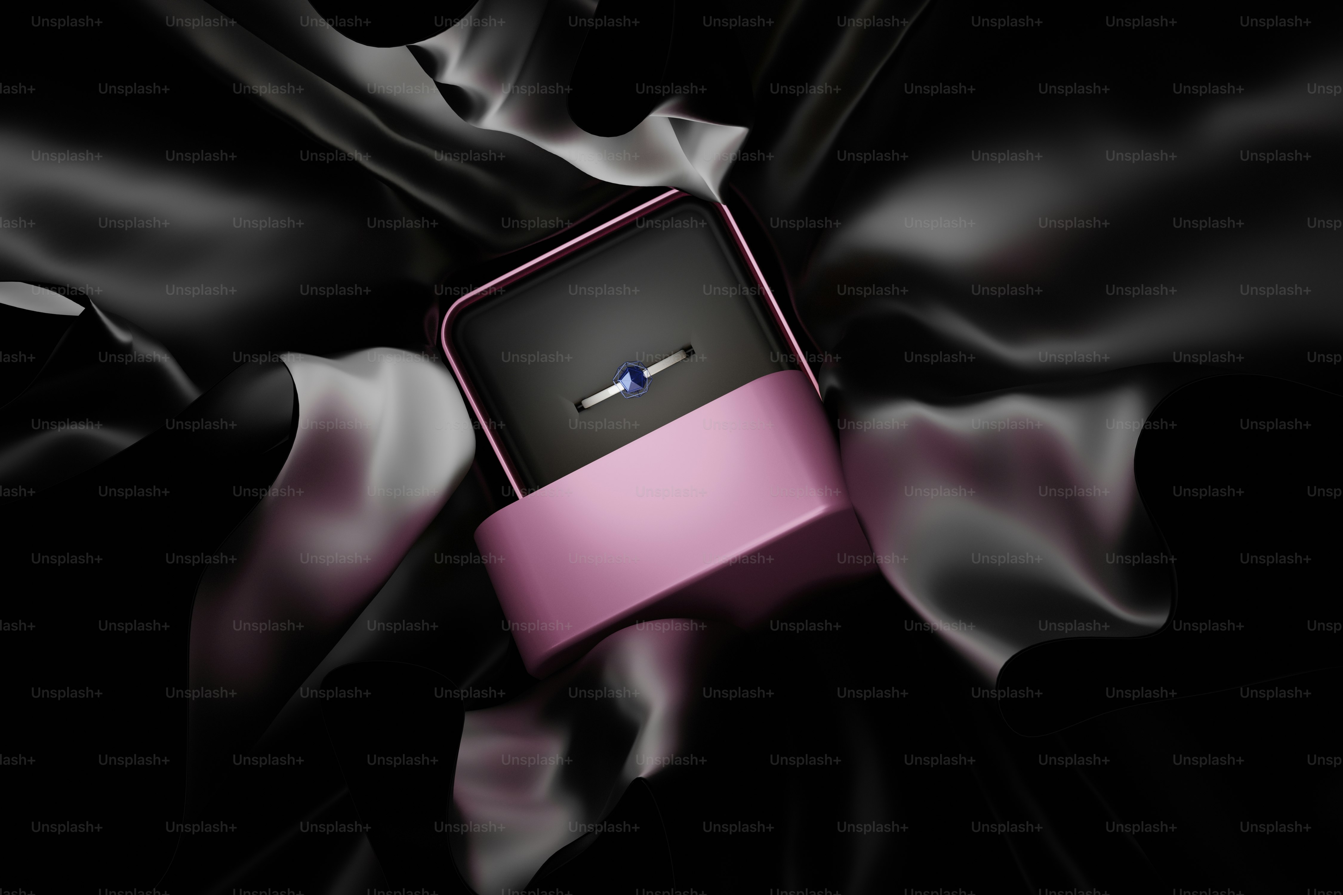 une boîte rose et noire posée sur un tissu noir
