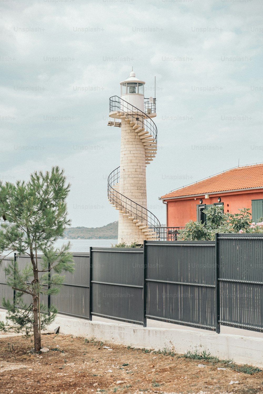a tall tower with a spiral staircase next to a fence