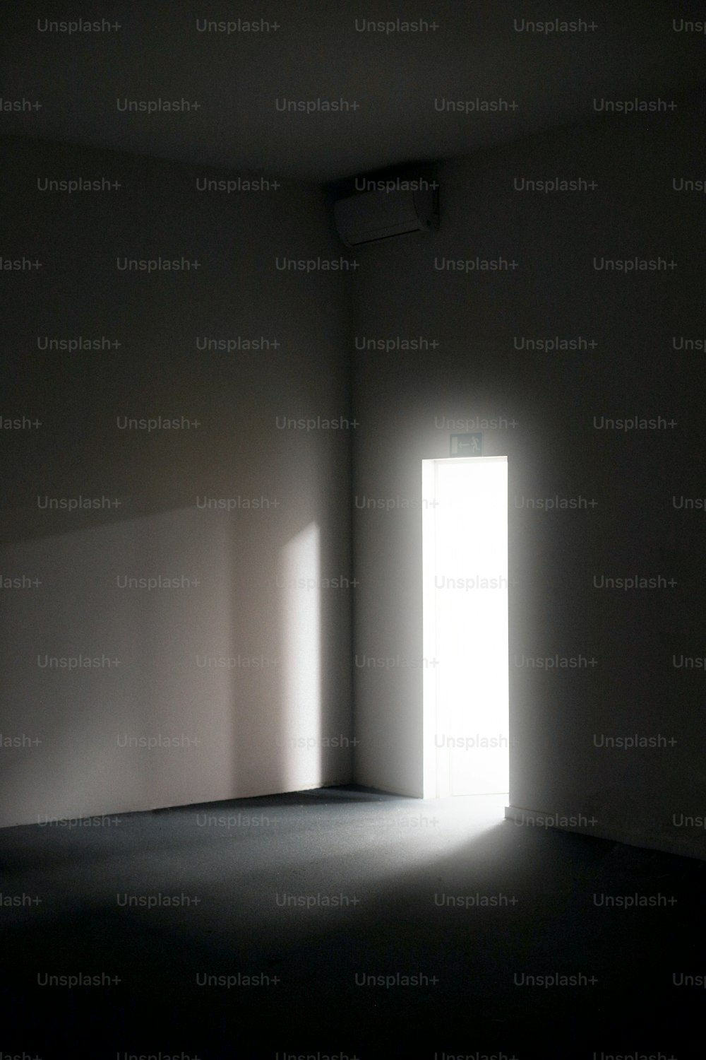 an empty room with a light coming through the door