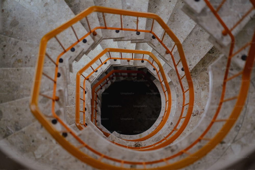 a spiral staircase with orange and white railings