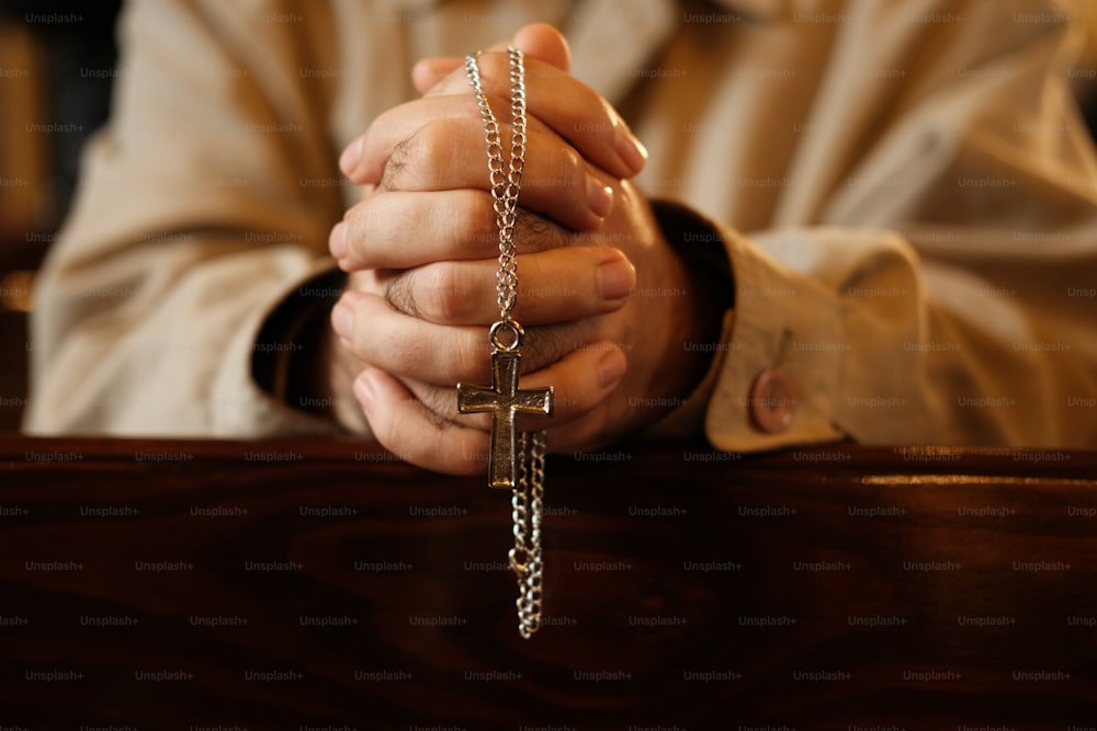 une personne tenant une croix dans ses mains