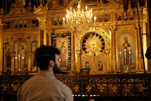 Un uomo in piedi di fronte a un altare d'oro