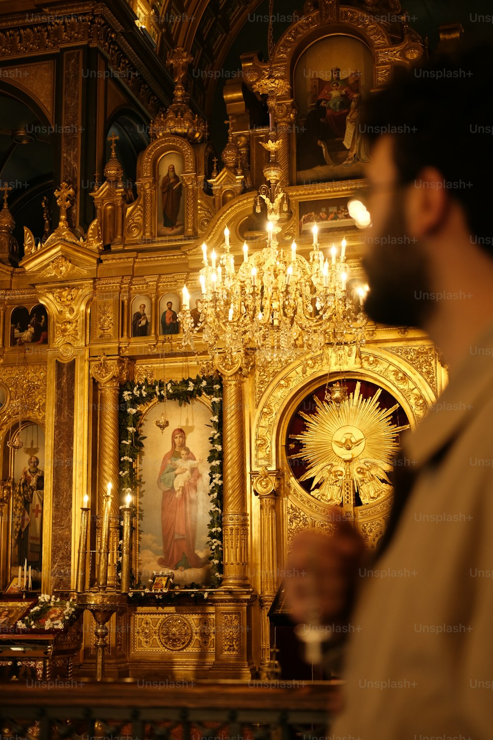 Un hombre parado frente a un altar dorado