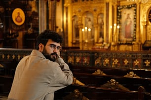 Un hombre sentado en una iglesia con una pipa en la boca