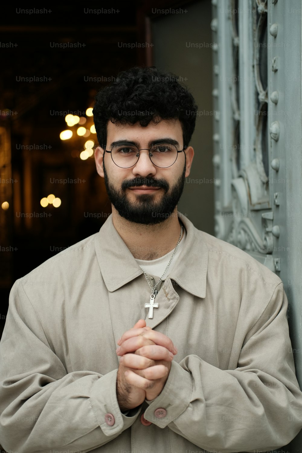 a man with a beard and glasses holding a cross
