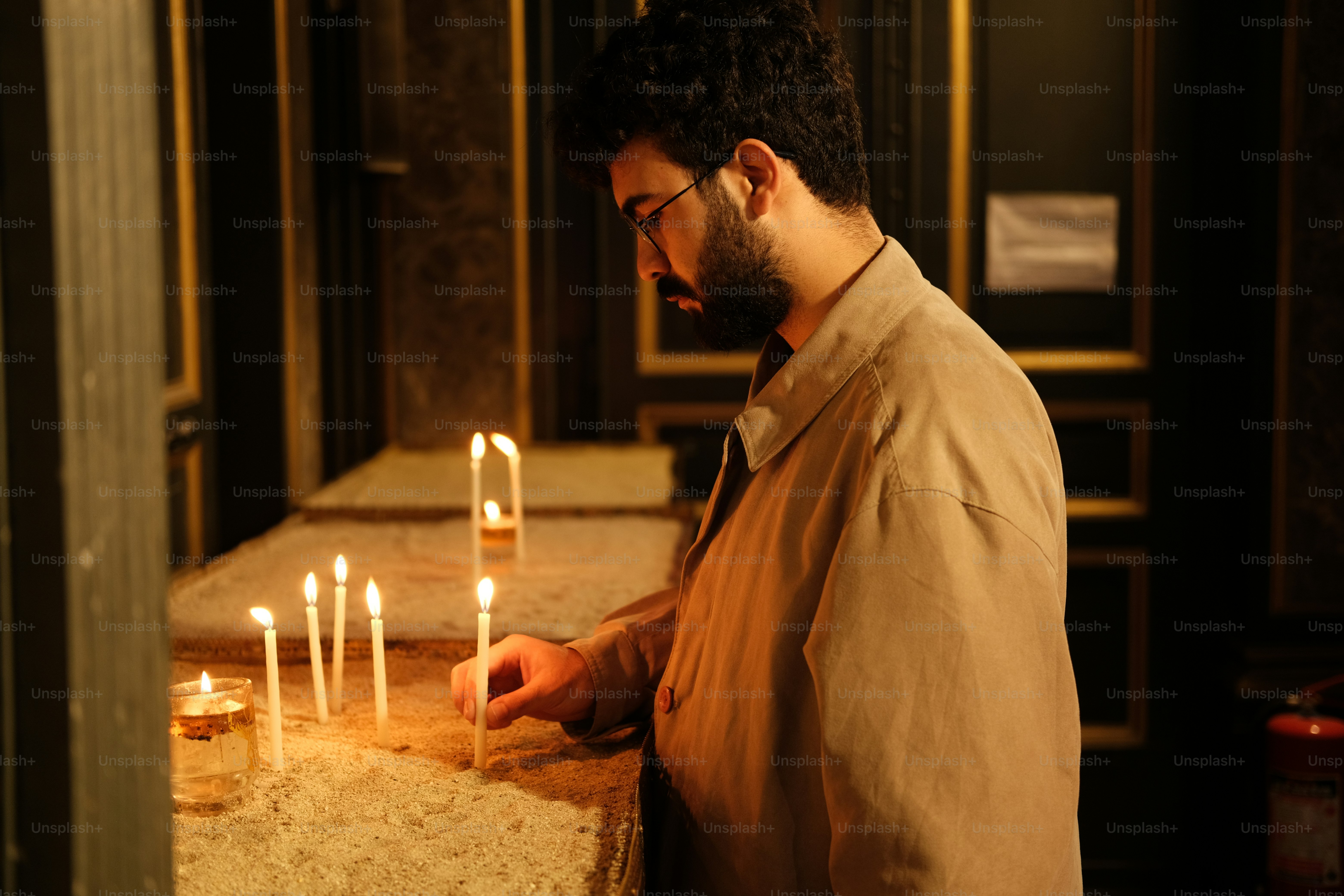 um homem acendendo velas em uma mesa em uma sala