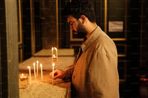 a man lighting candles on a table in a room