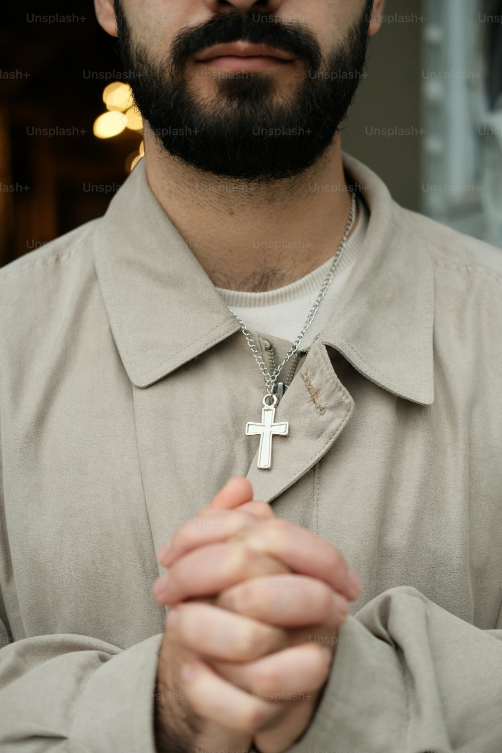 十字架のネックレスを身に着けたひげを生やした男