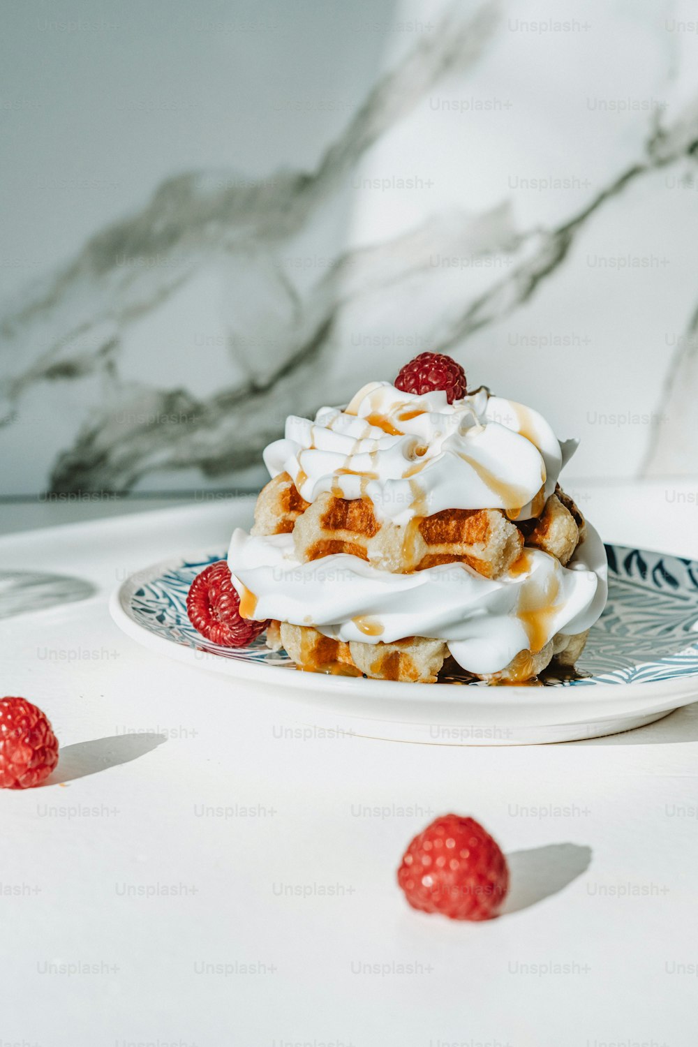 a waffle topped with whipped cream and raspberries