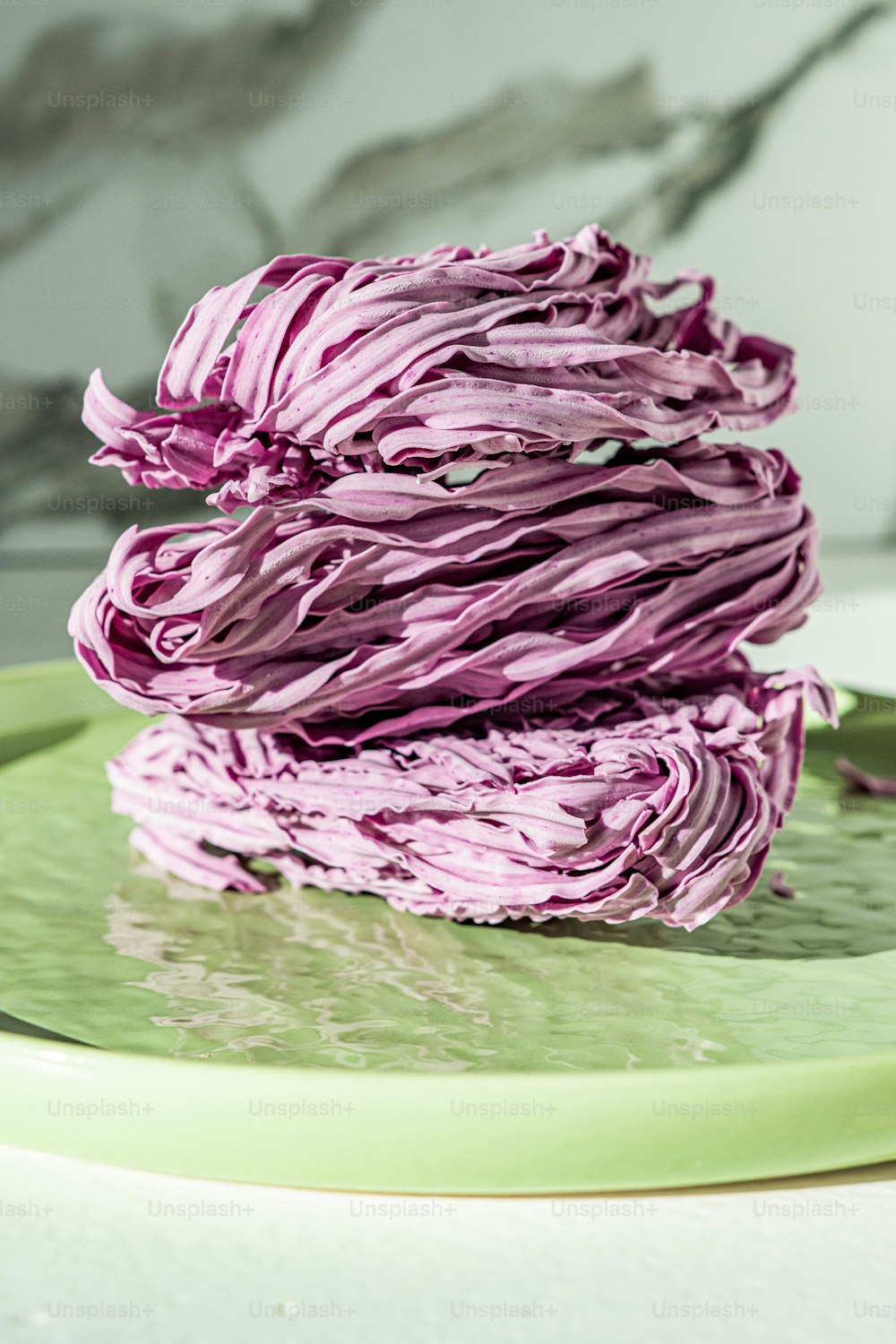 a stack of purple cabbage on a green plate