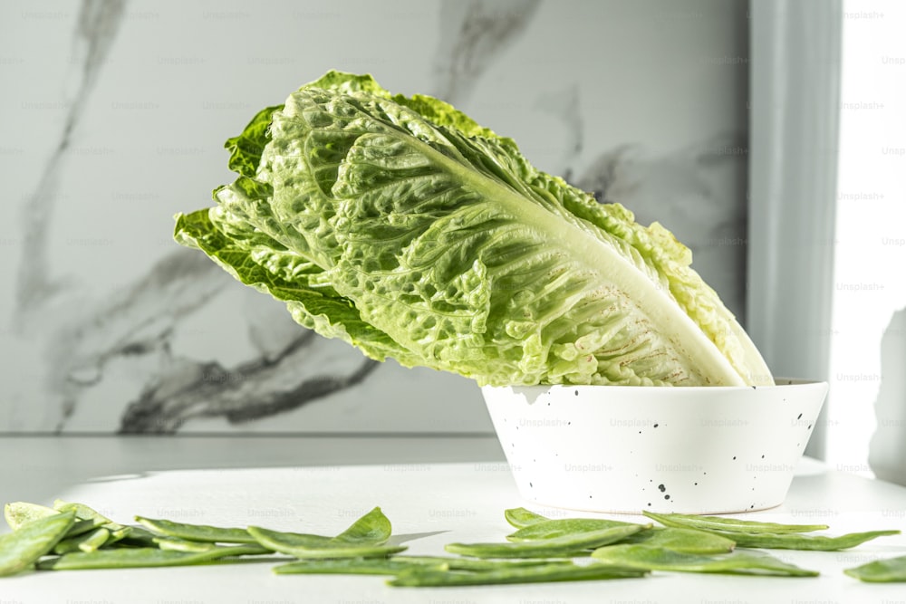 a lettuce in a white bowl on a table