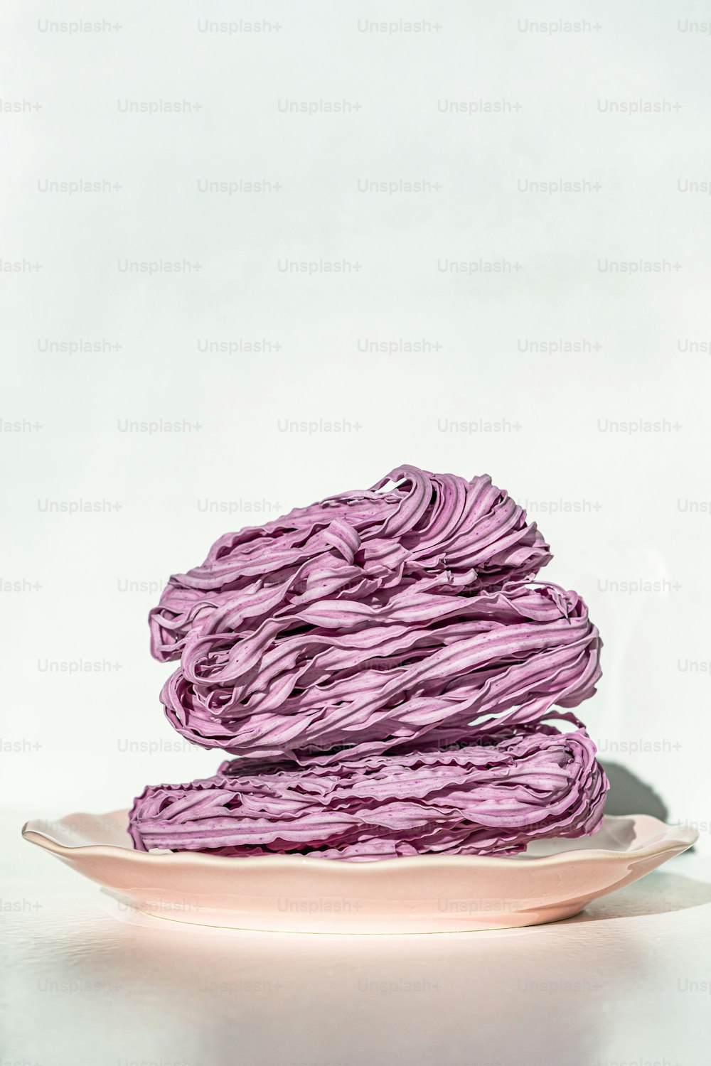un plato con una pila de telas púrpuras en él