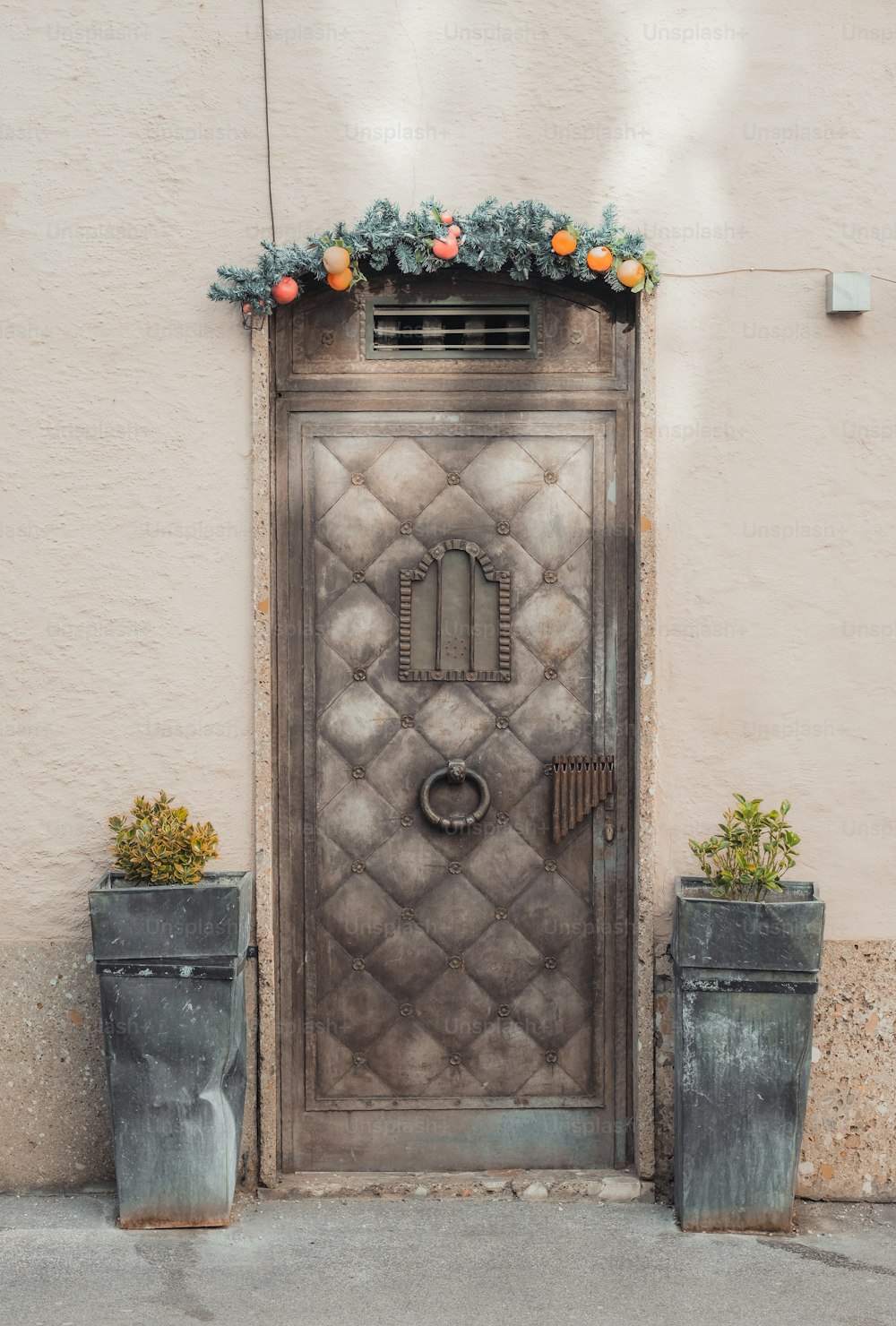 uma grande porta de metal com uma floreira ao lado dela