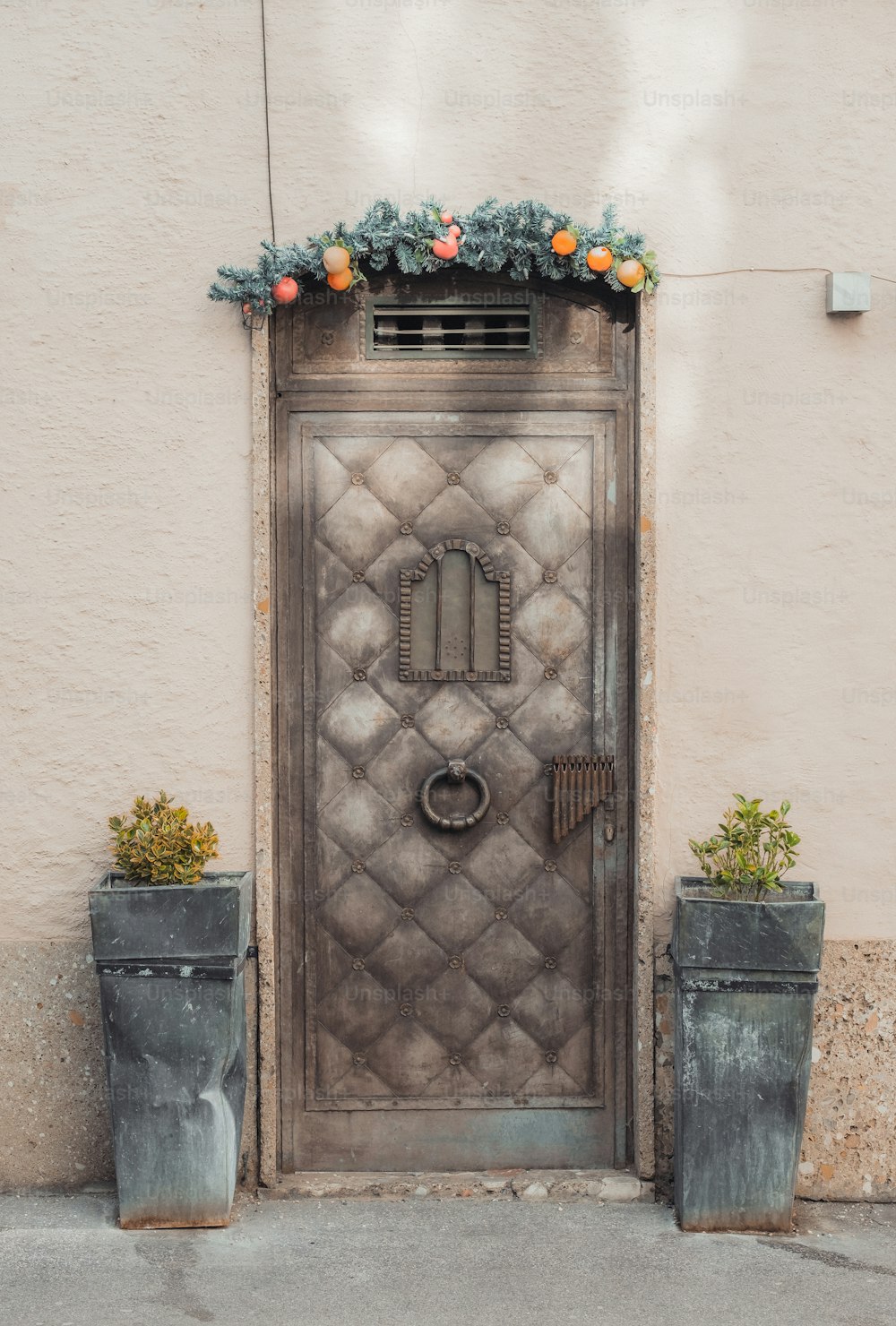 a large metal door with a planter next to it