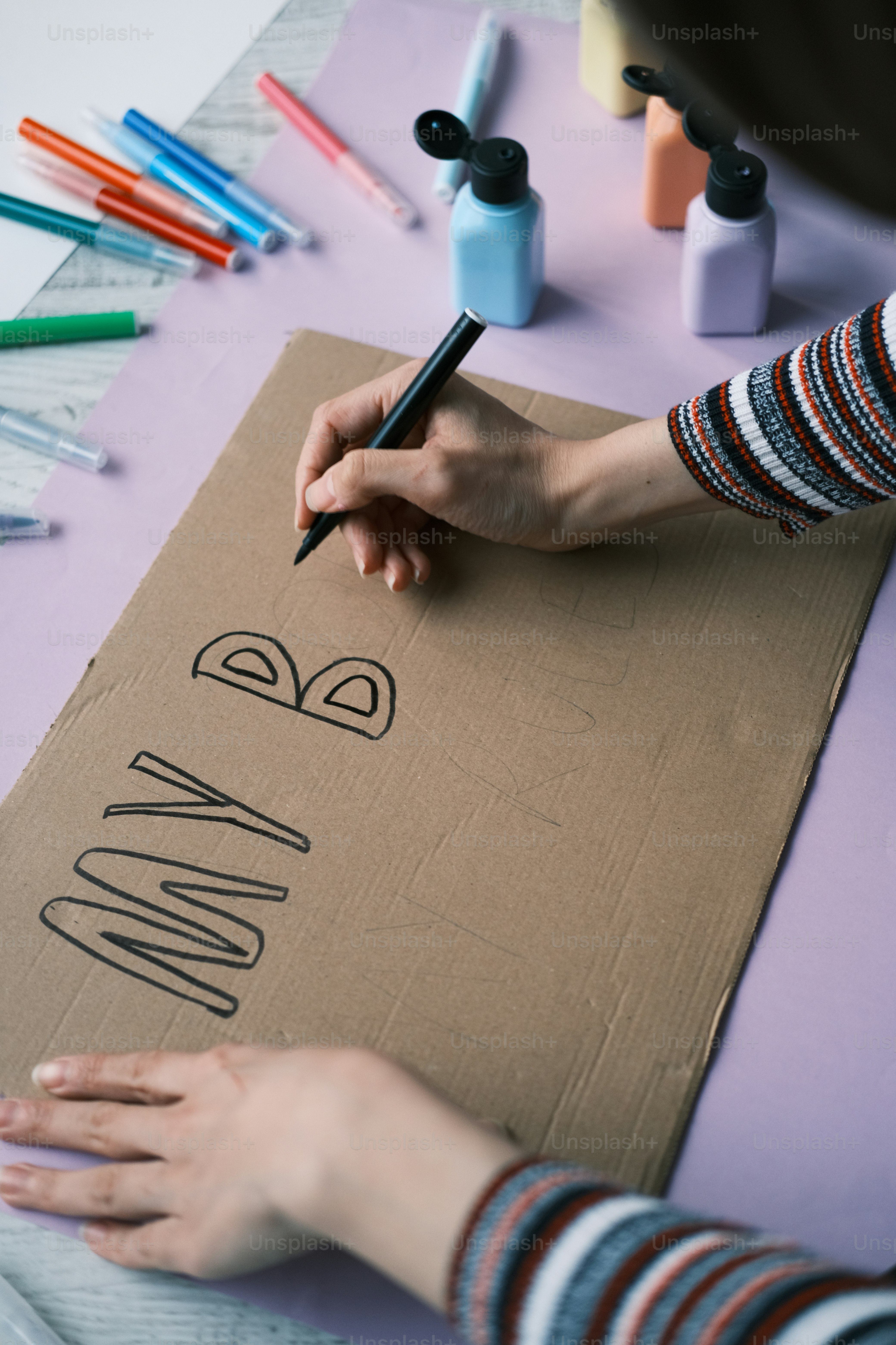 a person is writing on a cardboard box