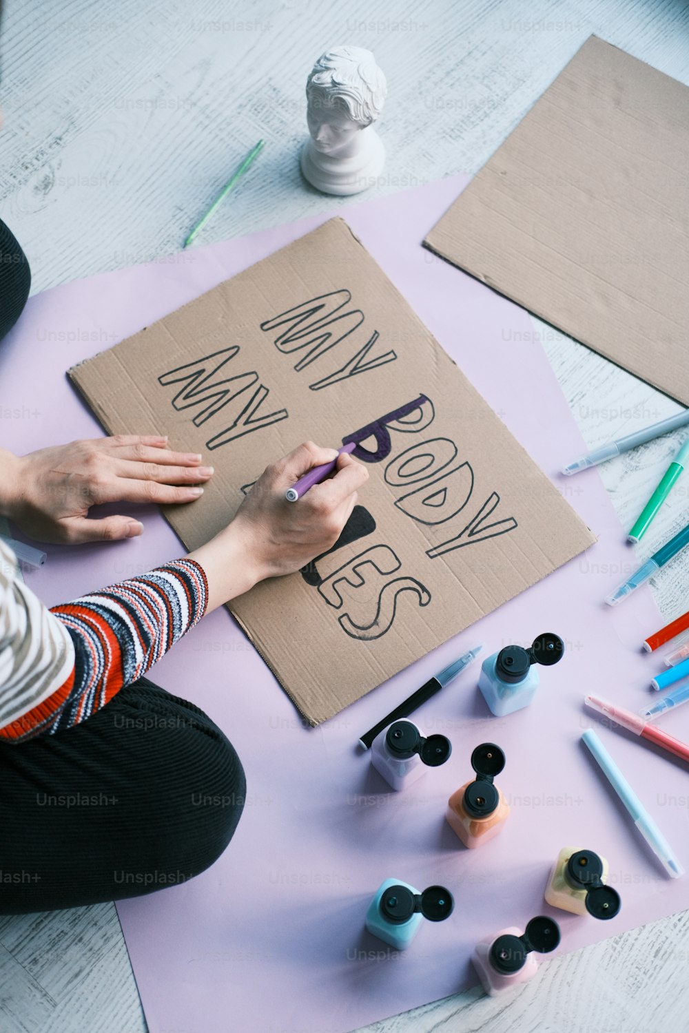 a person sitting at a table with a sign on it