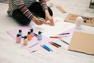 a person sitting on the floor with some crafting supplies