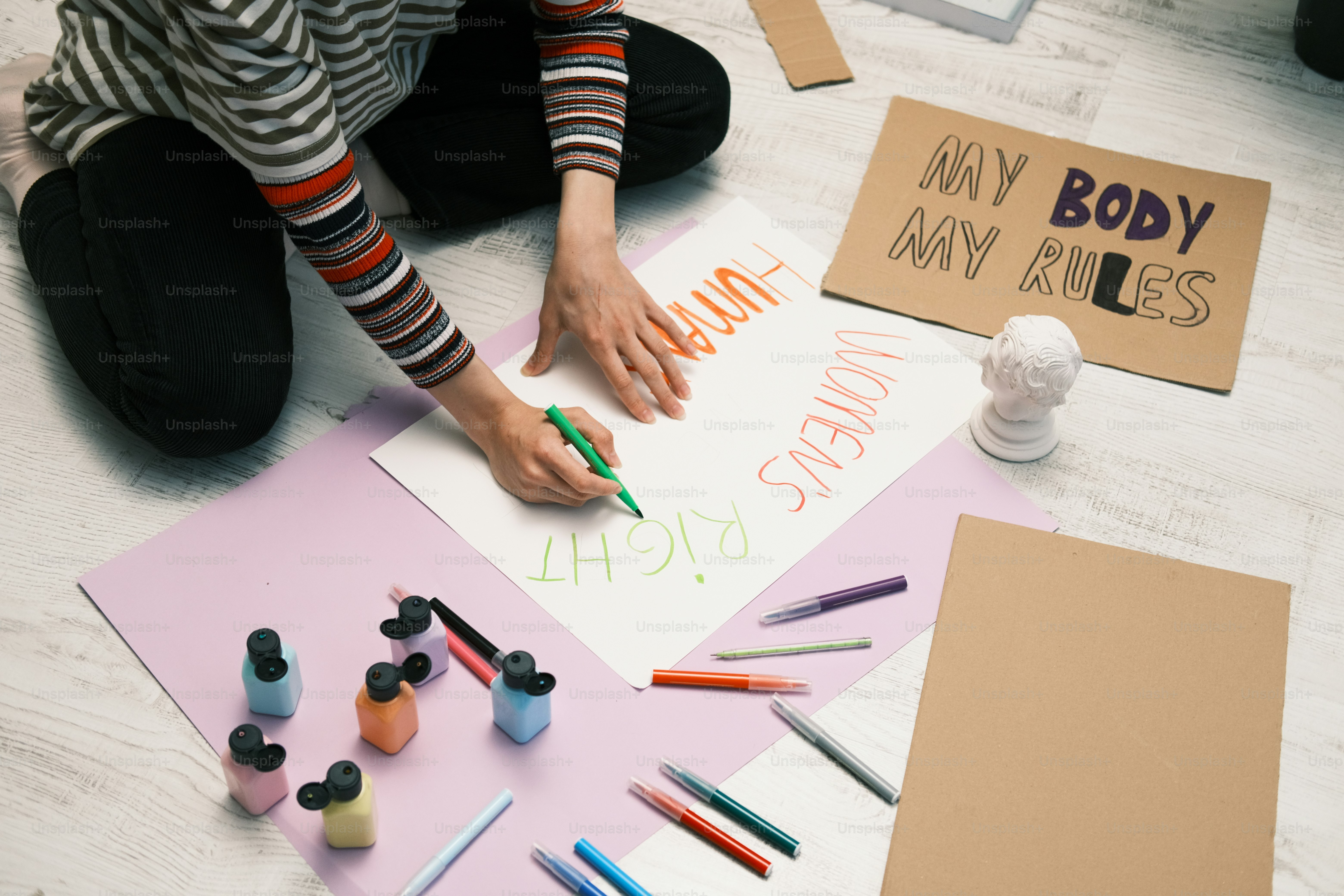 a person sitting on the floor with some crayons