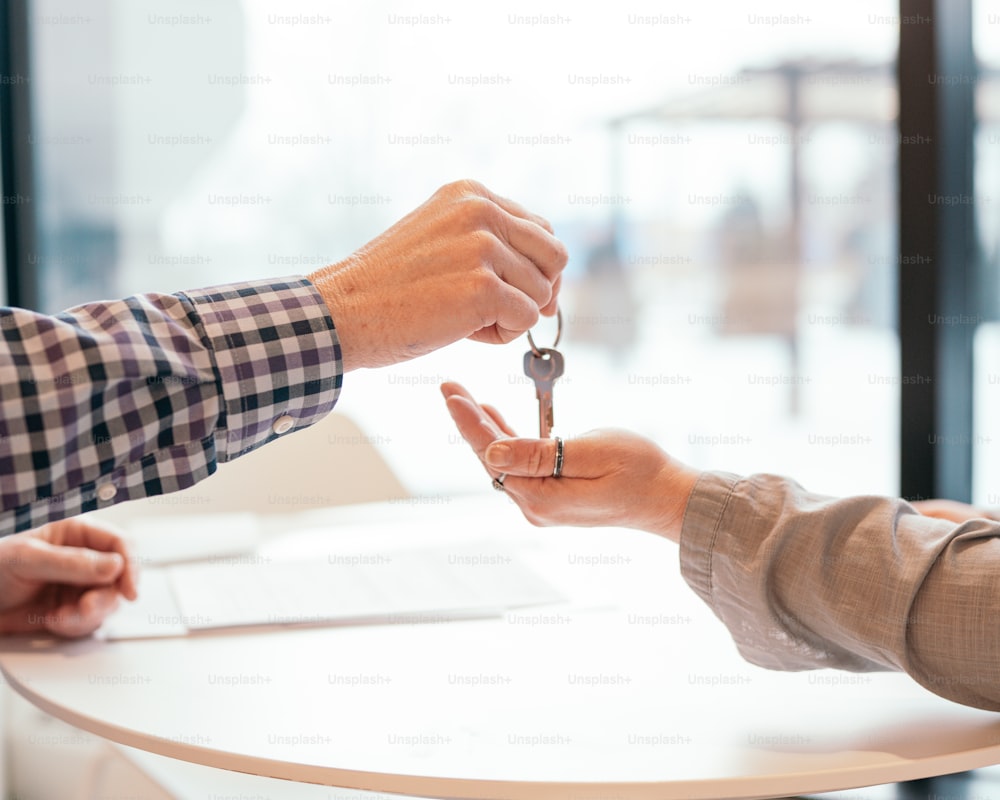 two people exchanging keys to each other at a table