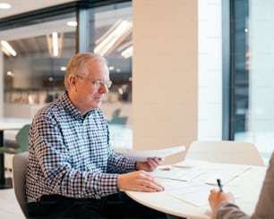 a man sitting at a table with a pen and paper