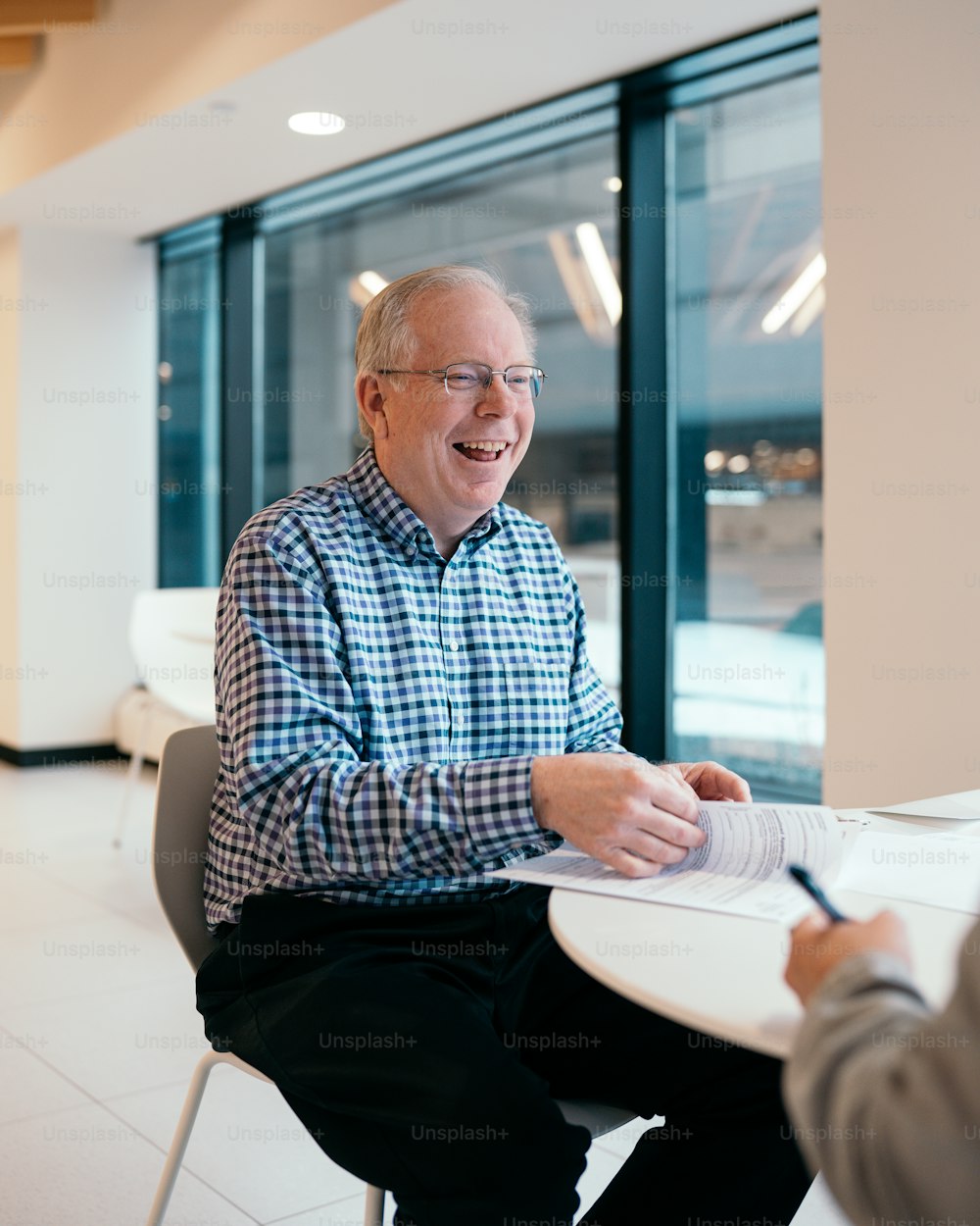 a man sitting at a table writing on a piece of paper