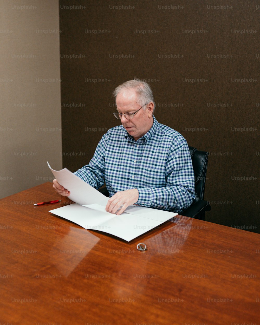 a man sitting at a desk with a book and pen