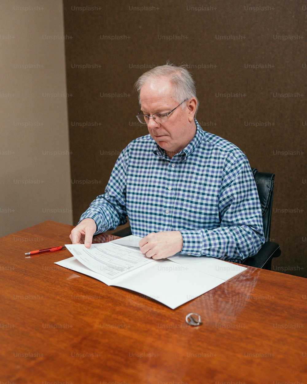a man sitting at a table with a pen and paper