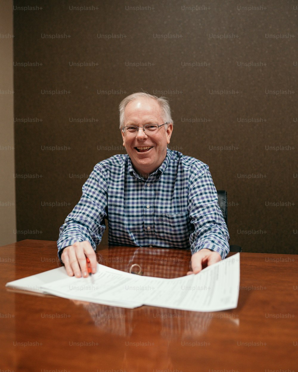 Un homme assis à une table avec un morceau de papier devant lui