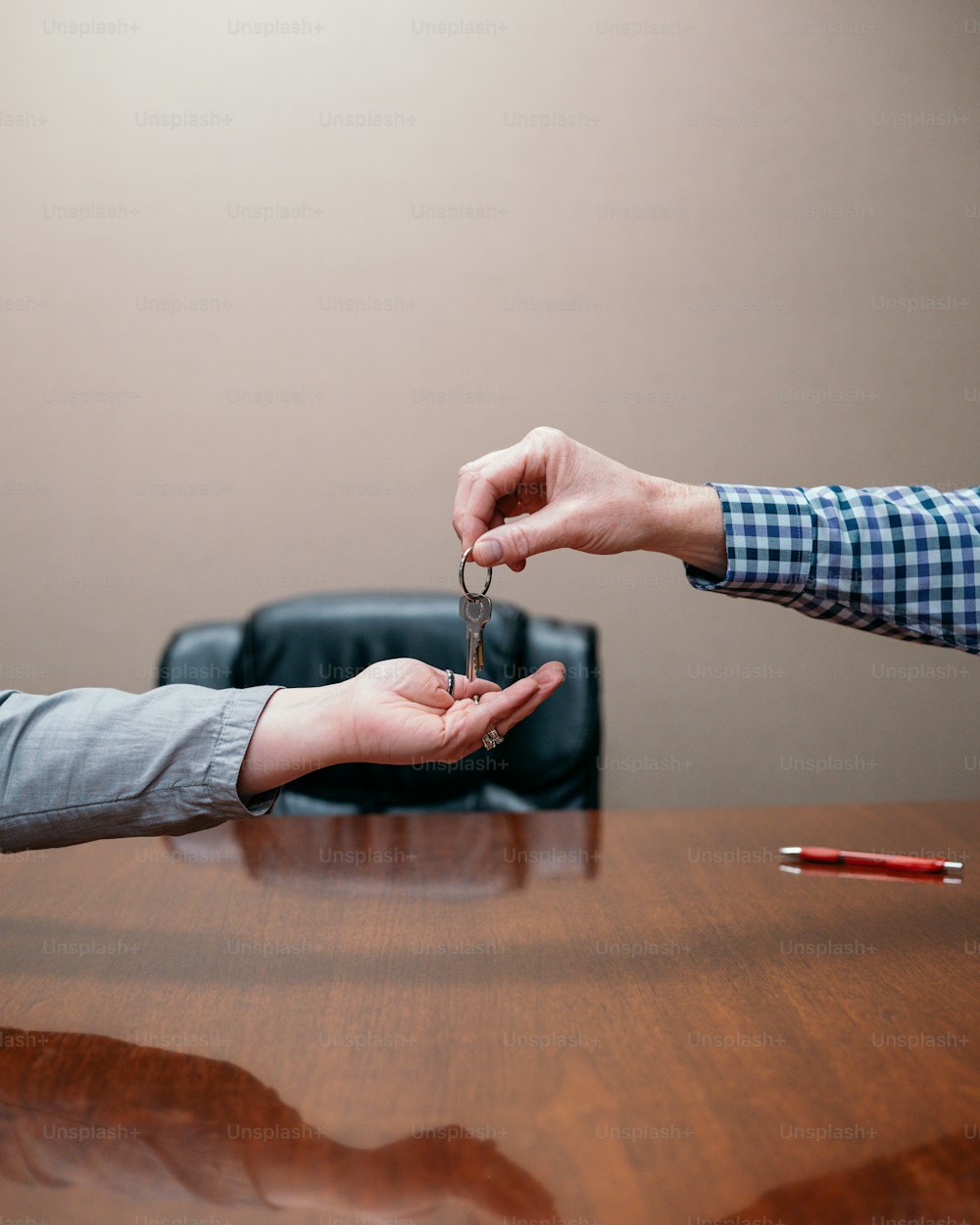 a person handing another person a key on a table