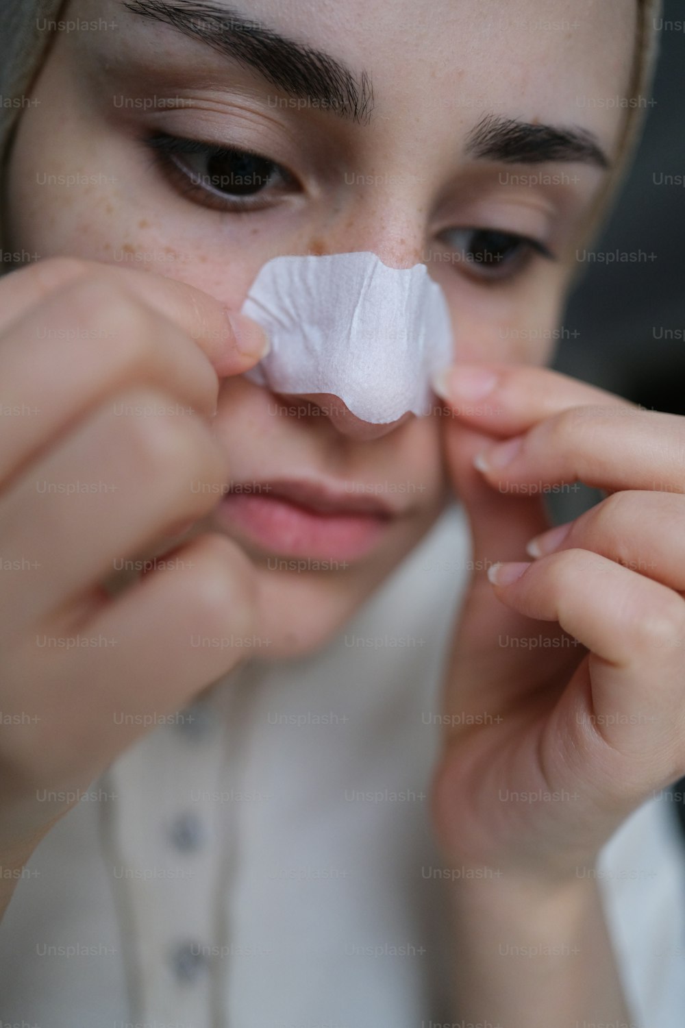a woman with a piece of tissue on her nose