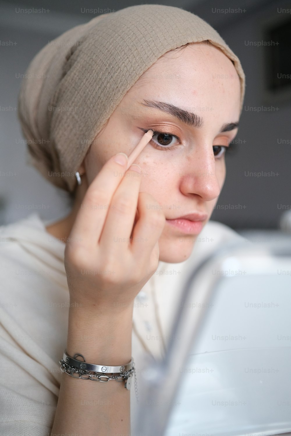 a woman with a head scarf on looking at a laptop