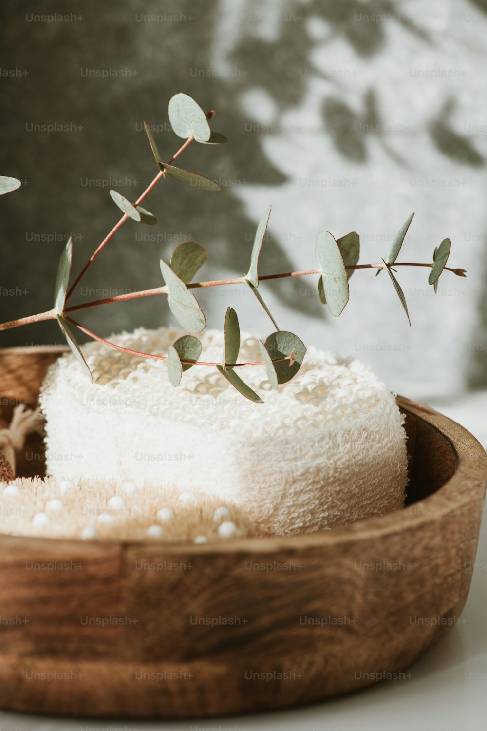 a wooden bowl filled with a cake covered in white frosting