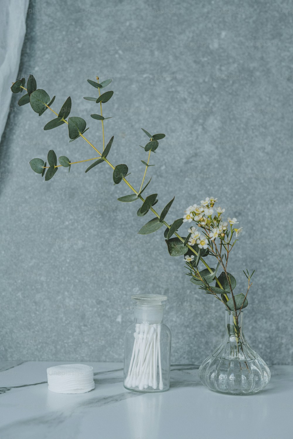 a vase filled with flowers next to a white container