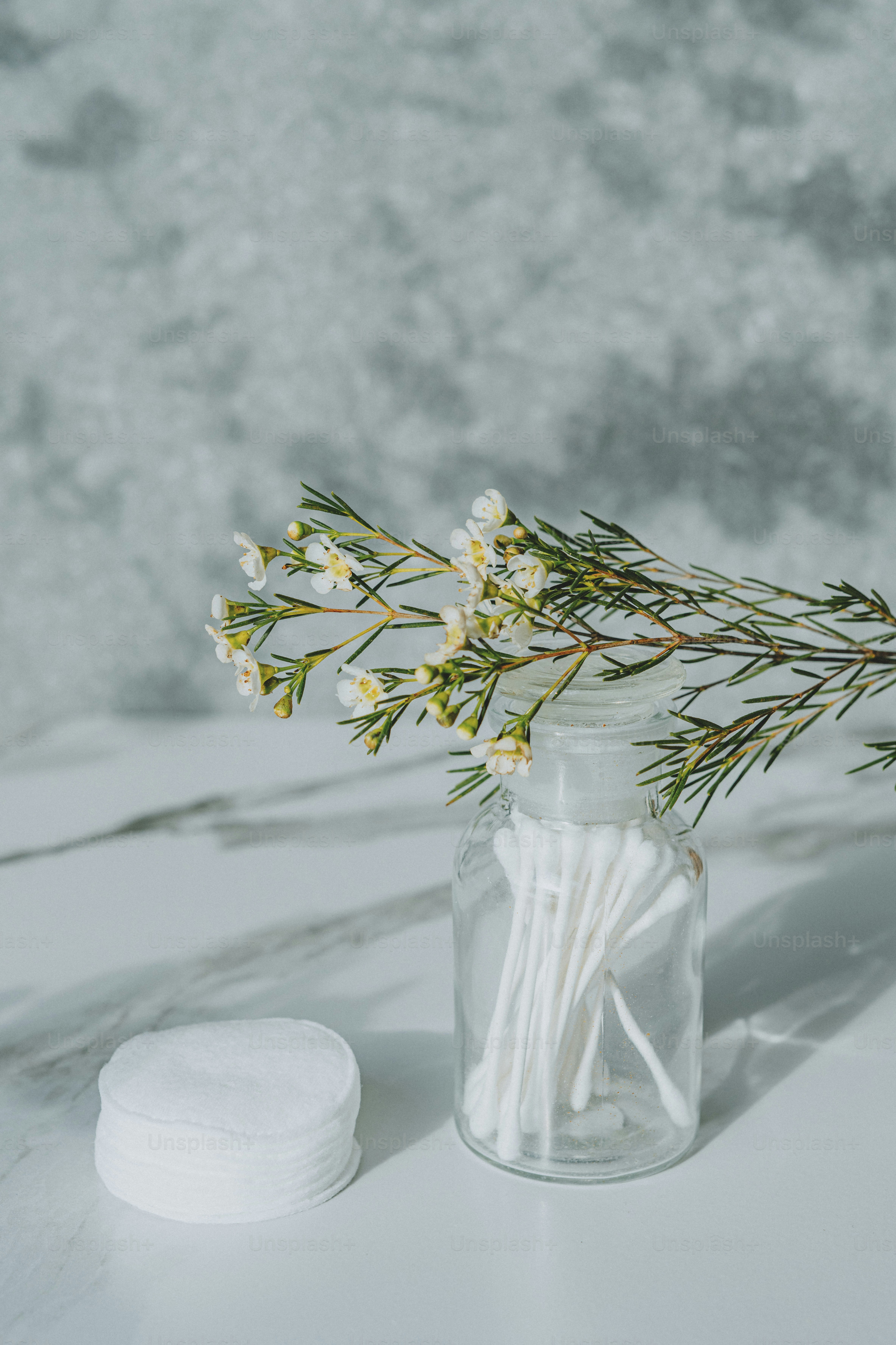 a glass jar filled with cotton swabs and flowers