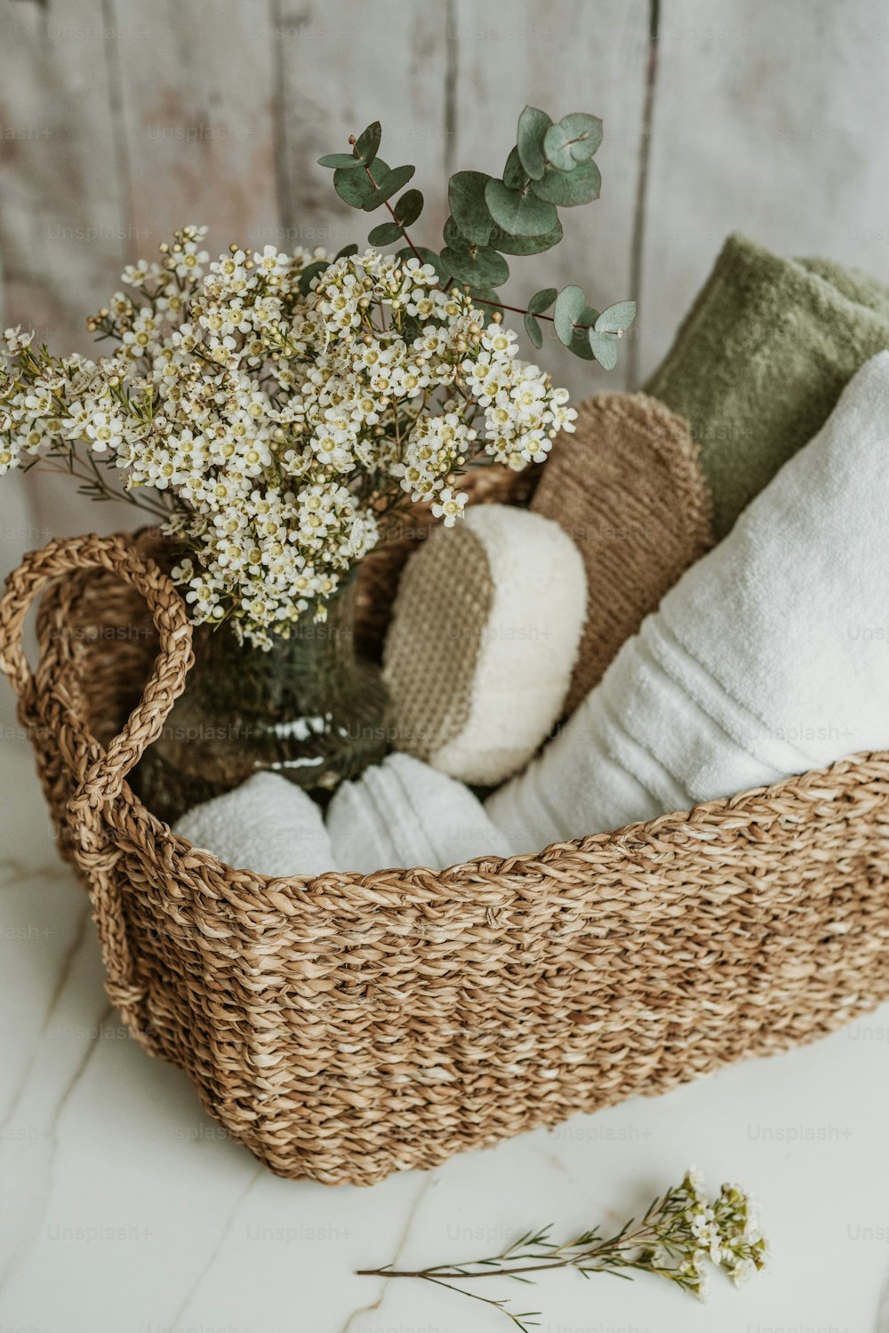 a basket filled with towels and a vase filled with flowers