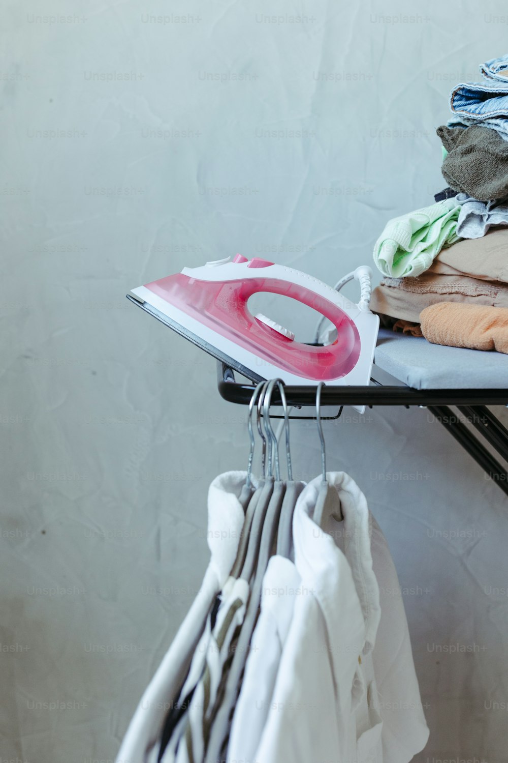 ironing board with iron and clothes on it