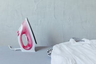 a pink and white iron sitting on top of a table