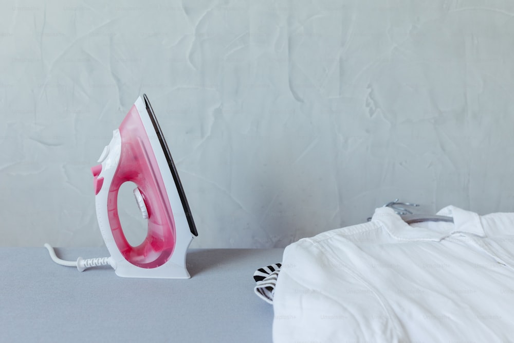 a pink and white iron sitting on top of a table