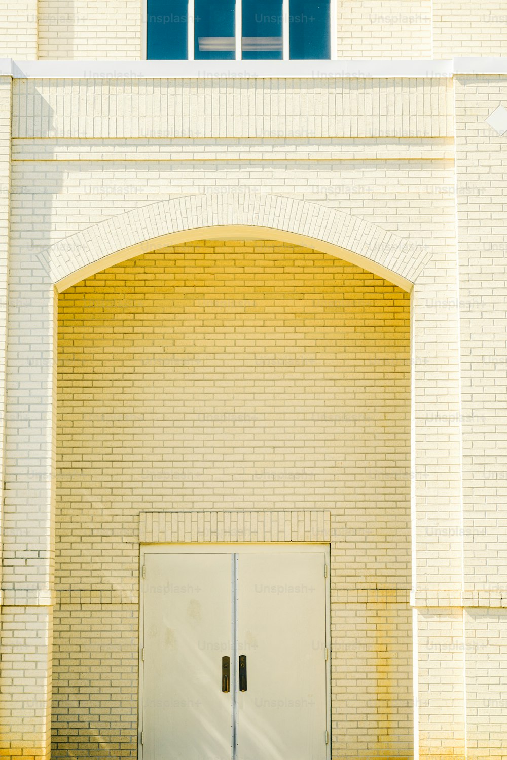 a couple of white doors sitting in front of a building