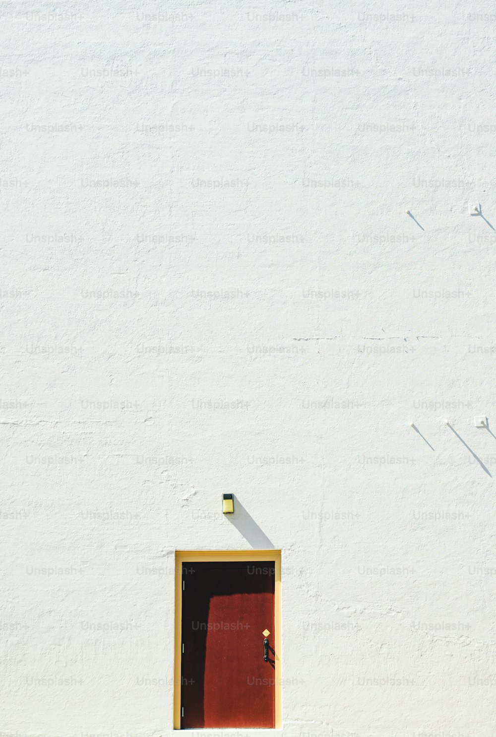 Un edificio blanco con una puerta roja y una puerta amarilla