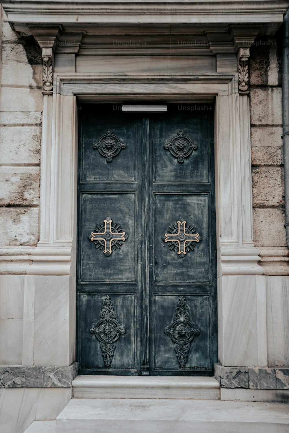 a large black door with a cross on it