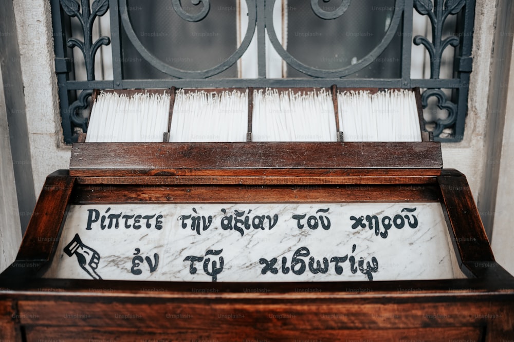 a wooden bench with writing on it in front of a window
