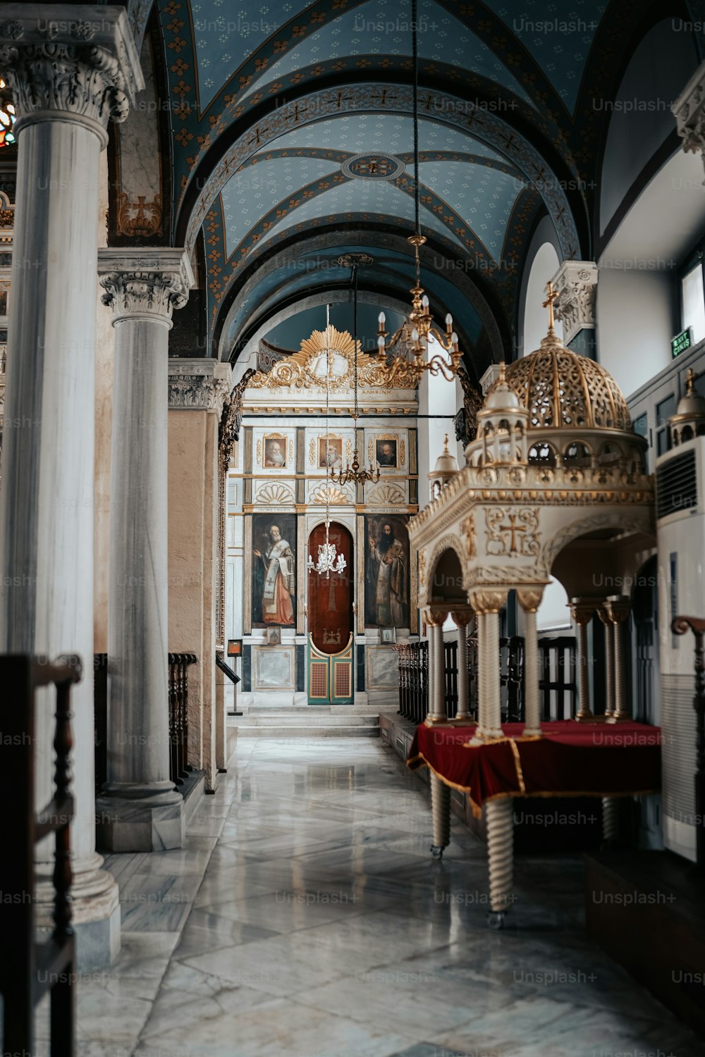 uma igreja com um grande altar e um pano vermelho no chão