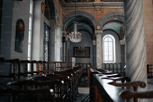 a church with pews and a chandelier hanging from the ceiling